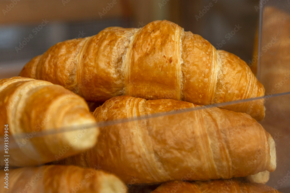 Fresh croissants on the counter. Traditional pastries for breakfast and coffee. Close-up.