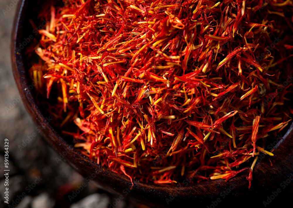Fototapeta premium Saffron in bowl and saffron tea,wooden background, closeup