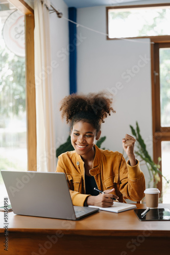 African woman are delighted and happy with the work they do on their tablet, laptop and taking notes at the office..