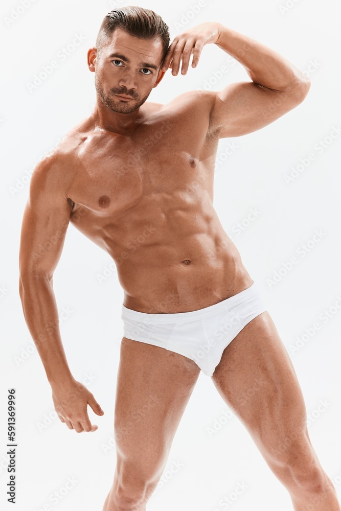 Man athletic body bodybuilder in briefs with naked torso abs full-length in the background, fitness classes. Advertising, sports, active lifestyle, competition, challenge concept. Man athletic body bodybuilder in briefs with naked torso abs full-length in the background, fitness classes. Advertising, sports, active lifestyle, competition, challenge concept.