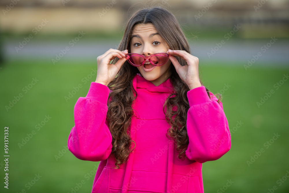 photo of surprised stylish teen girl wear hoodie. stylish teen girl outdoor.
