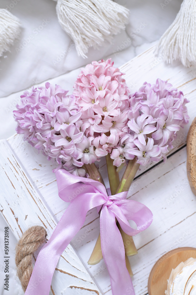 A bouquet of hyacinths tied with a pink ribbon on a white tray