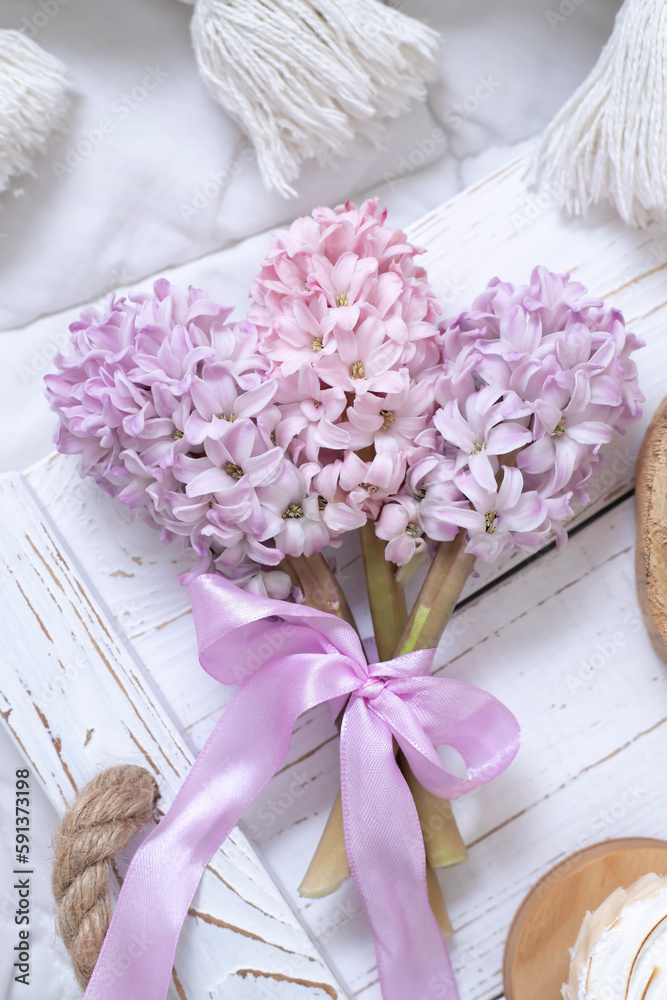 A bouquet of hyacinths tied with a pink ribbon on a white tray A bouquet of hyacinths tied with a pink ribbon on a white tray