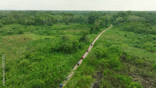 Aerial shot of a group of motorbikes driving on a small road in the amazonian Rainforest. photo