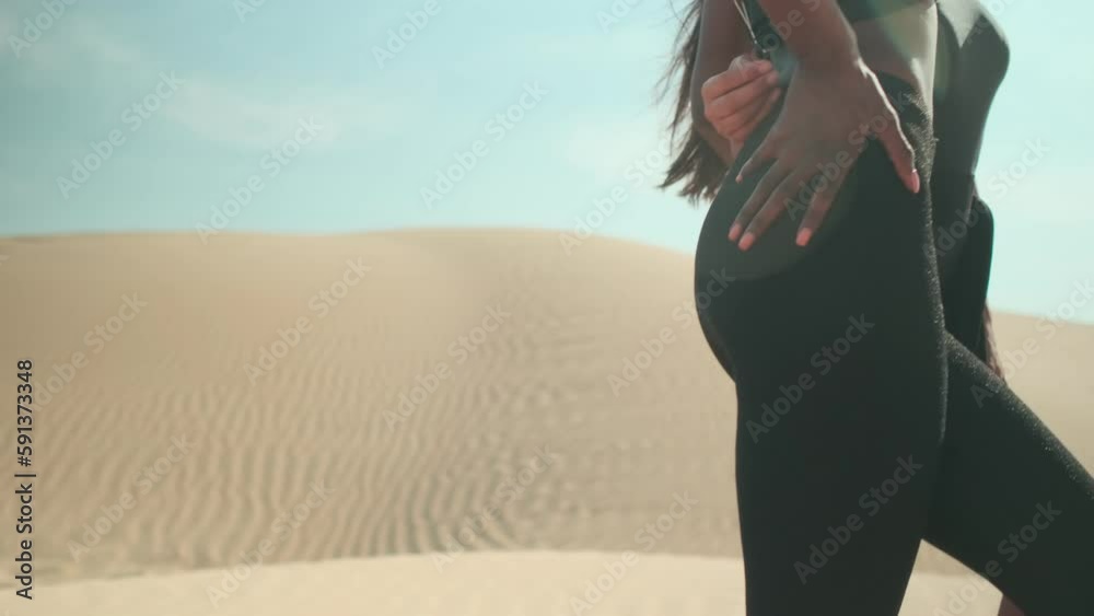 Two girls pose standing barefoot on the sand Two girls pose standing barefoot on the sand