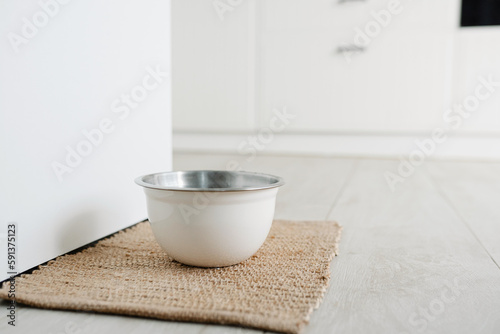 Fototapeta Naklejka Na Ścianę i Meble -  White metalic bowl with dog food or water on the floot in the kitchen home