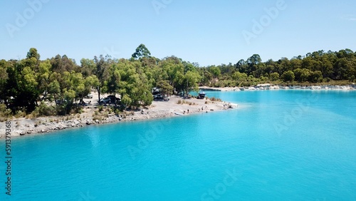 Blue lake surrounded by trees with a blue sky