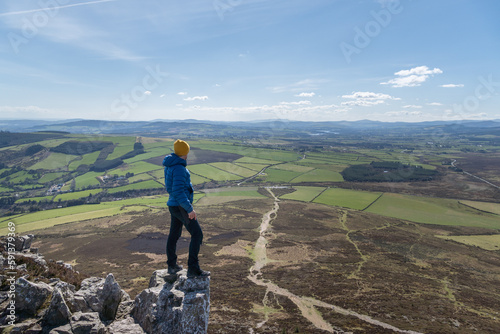 Hiker man standing on rock admiring wicklow mountain scenery