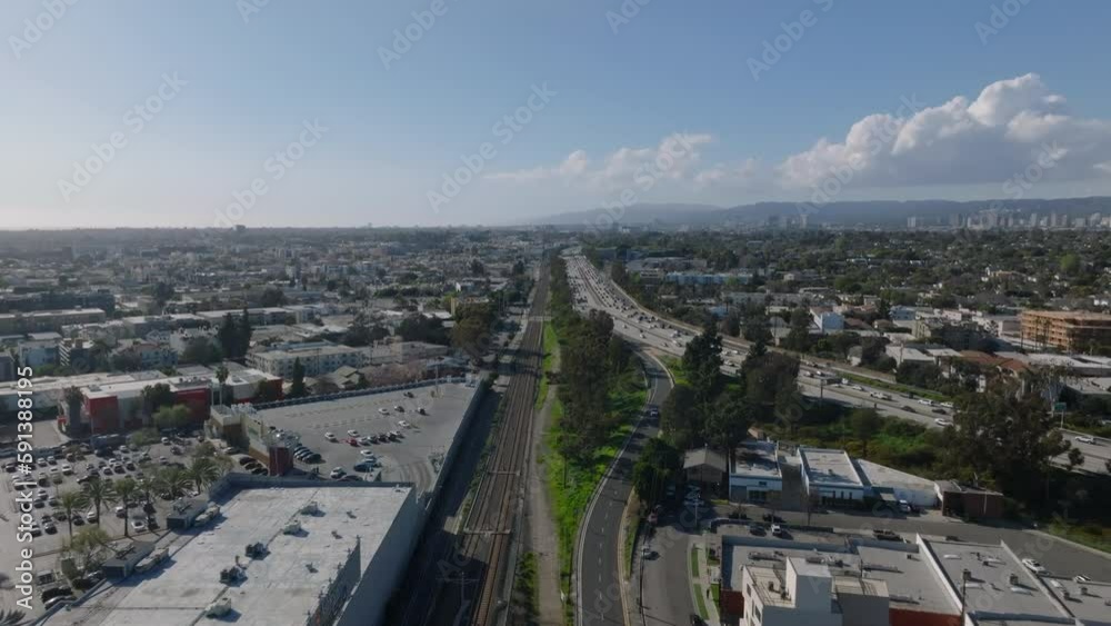 Heavy traffic on multilane highway leading through urban neighbourhood. Trunk road and railway surrounded by residential borough. Los Angeles, California, USA Heavy traffic on multilane highway leading through urban neighbourhood. Trunk road and railway surrounded by residential borough. Los Angeles, California, USA