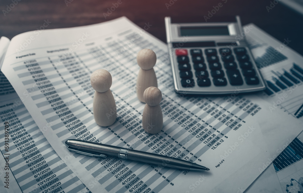 A pen and calculator and The wooden doll represents the employee of the company line up on business graph in workplace and them represents new employee, search job or job career. A pen and calculator and The wooden doll represents the employee of the company line up on business graph in workplace and them represents new employee, search job or job career.