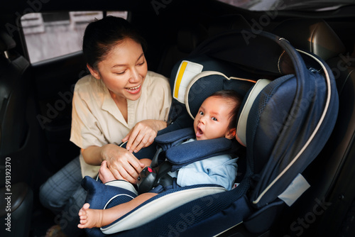 mother take care her newborn baby in car seat. play and talking with child