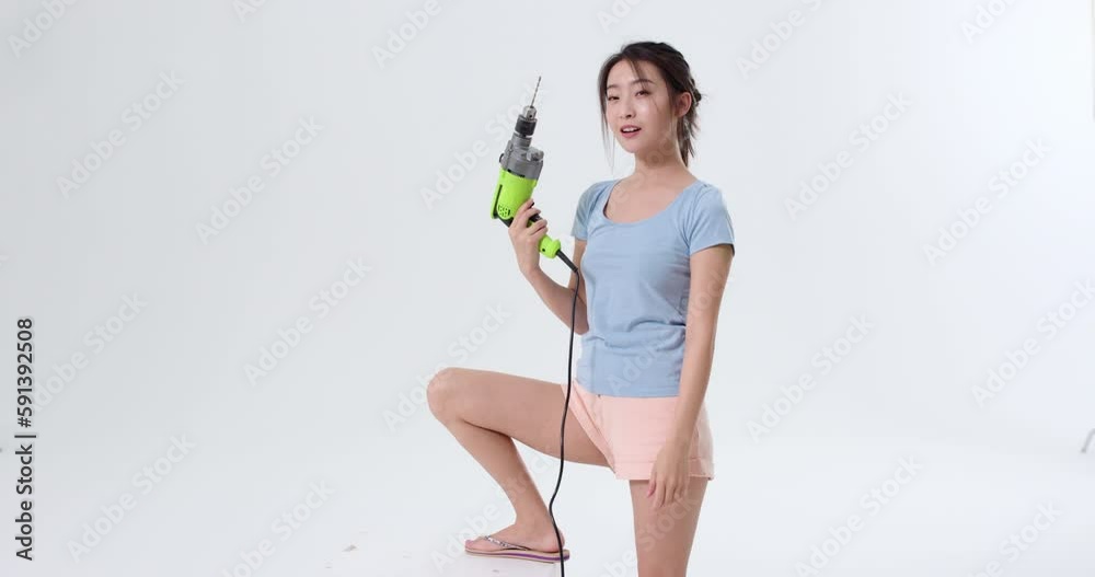 Cheerful young woman holding a hand drill,4K Cheerful young woman holding a hand drill,4K