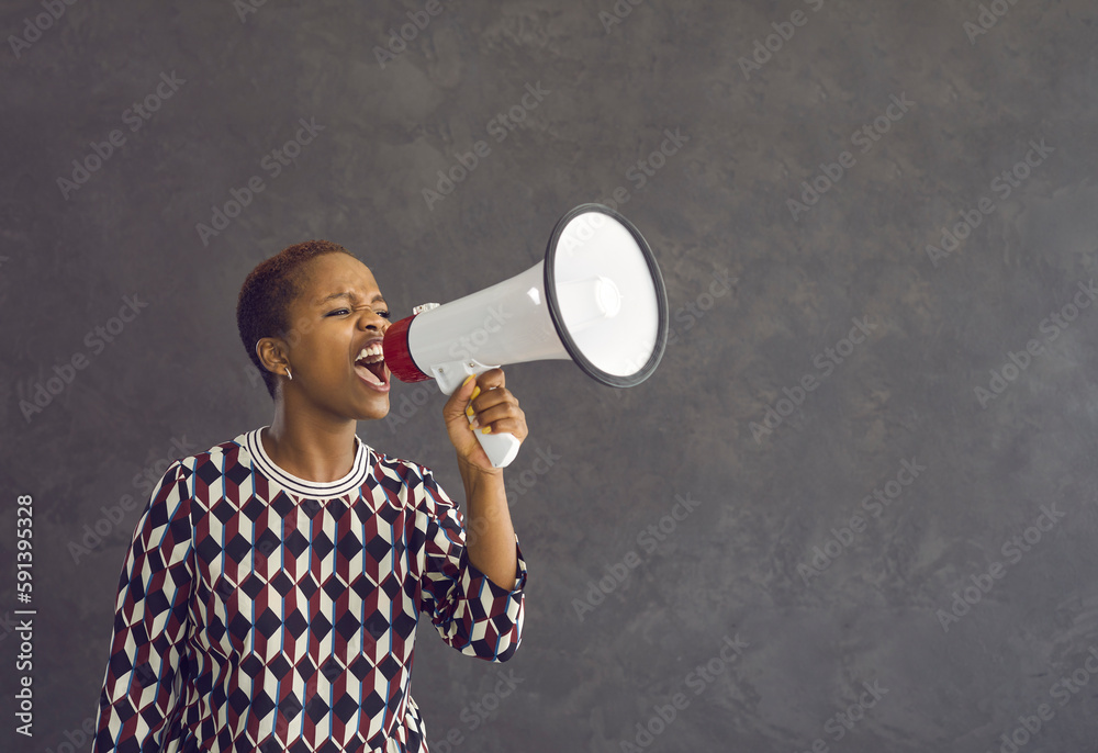 Angry mad young African American woman hold loudspeaker make announcement of deal or sale. Millennial gen z ethnic girl feel motivated get attention screen yell in speaker about good promotion. - obrazy, fototapety, plakaty 