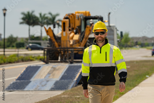 Portrait of builder in a construction site. Builder with excavator ready to build new house. Construction builder wear building uniform on excavation truck digging, builder in hardhat helmet.