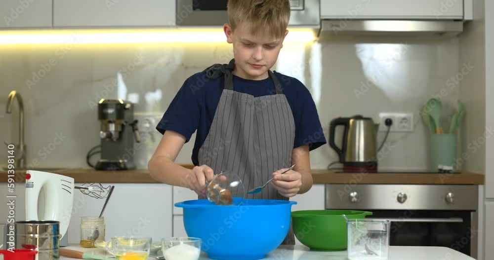 Young boy preparing dough for cookies on the kitchen alone. Young boy preparing dough for cookies on the kitchen alone.