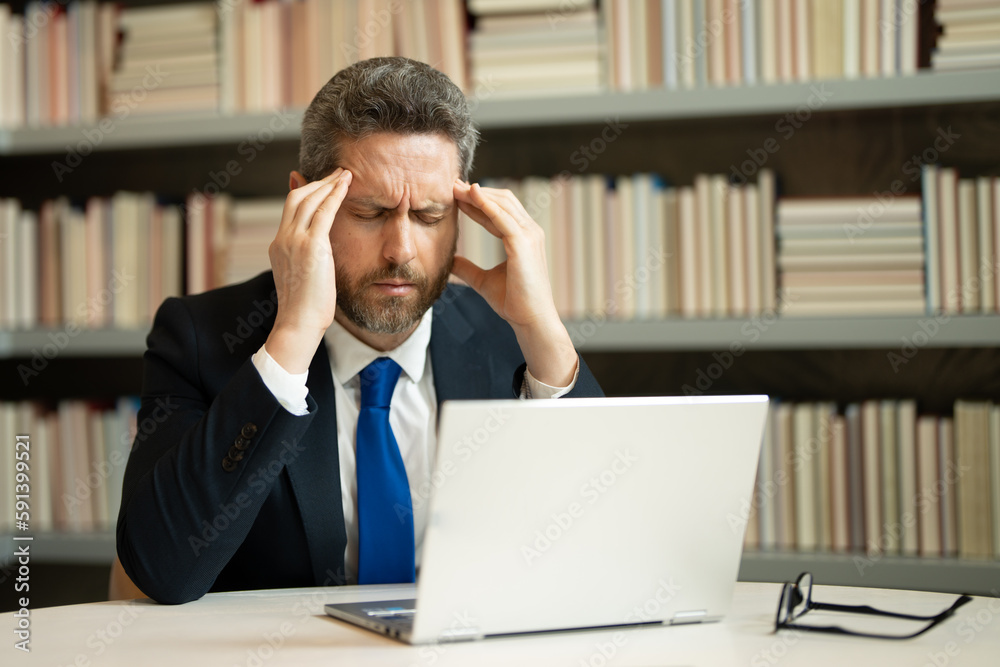 Sad business man having a terrible headache. Exhausted man feeling unhealthy, upset about headache illness. Stressed middle-aged man having headache. Migraine and headache concept. Sad business man having a terrible headache. Exhausted man feeling unhealthy, upset about headache illness. Stressed middle-aged man having headache. Migraine and headache concept.
