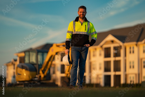 Portrait of worker small business owner. Construction worker with hardhat helmet on construction site. Construction engineer worker in builder uniform with excavation digging. Worker construction.