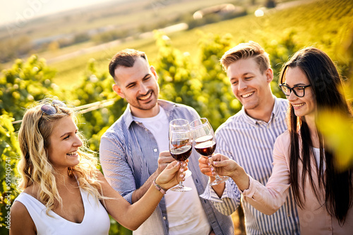 Young friends having fun outdoors - Happy people enjoying harvest time together at farmhouse winery countryside - Tasting red wine at vineyard