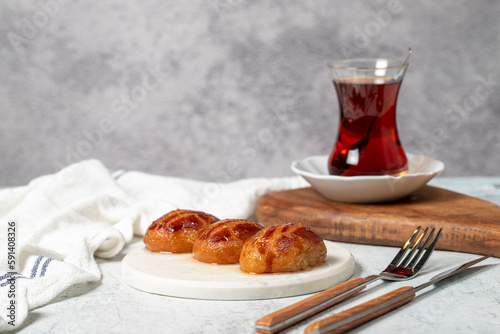 Sekerpare or bademdpare dessert. Turkish Ramadan dessert. Şekerpare dessert with sherbet on a marble serving plate photo