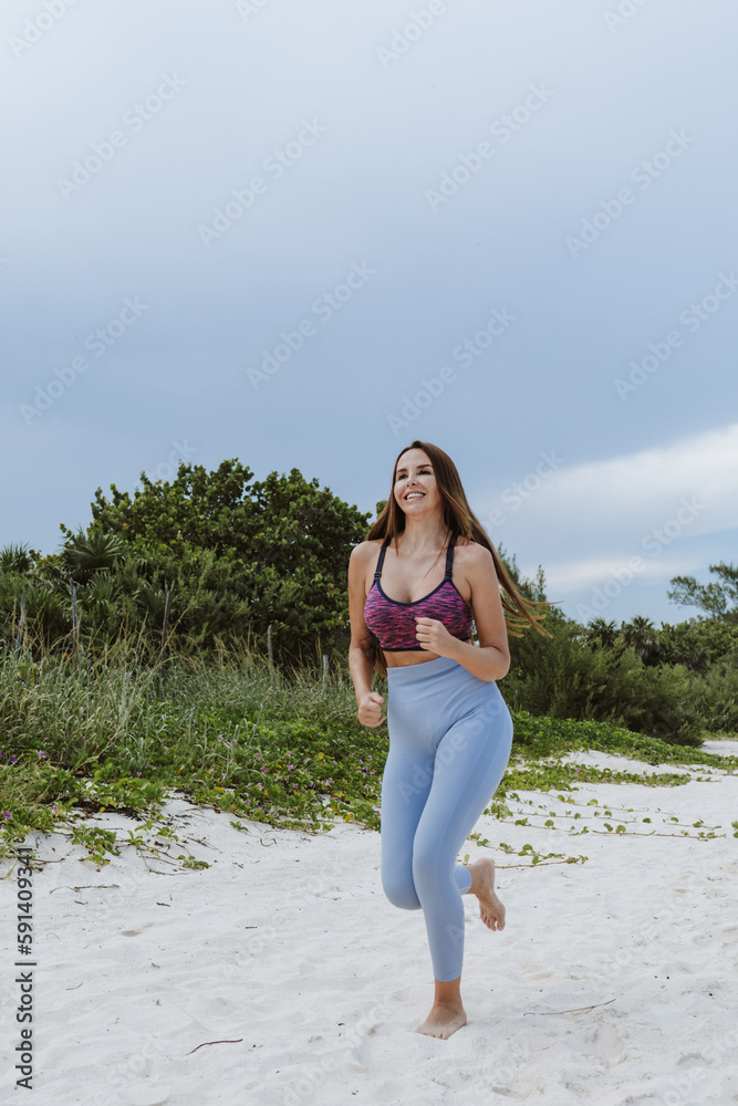 latin young woman running at beach in Mexico Latin America, hispanic people