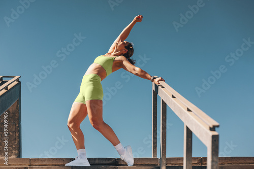 Energetic sporty woman in her 30s having fun exercising outdoors in daylight