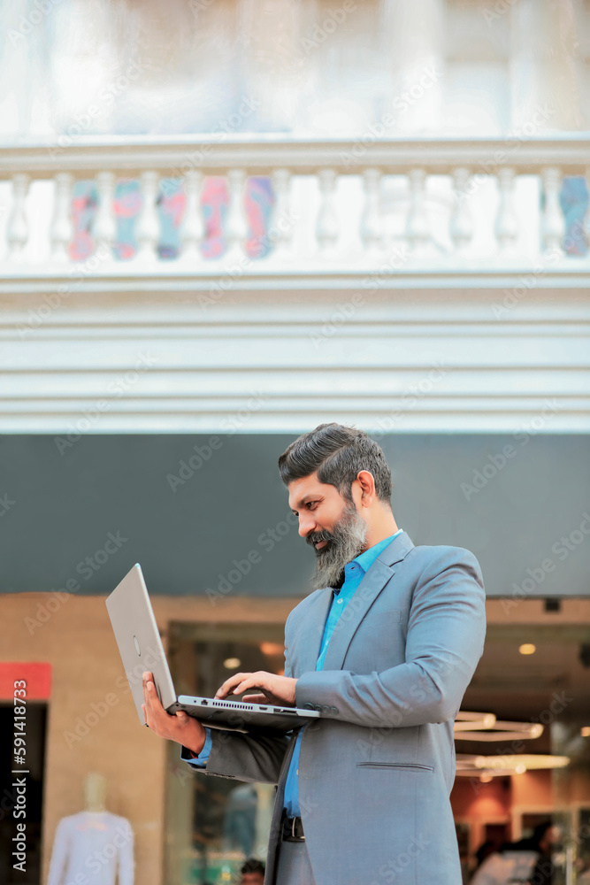 Indian businessman working on laptop at outdoor