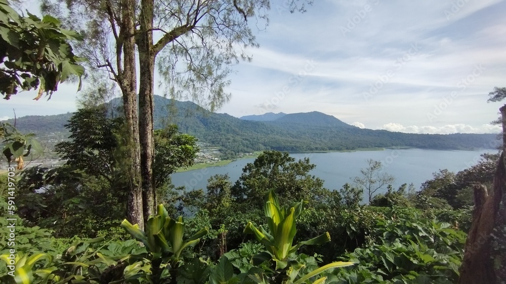 Bali Island, Indonesia 09 April 2023 - beautiful lake between green hills and natural forest.