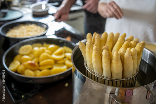 Old Woman cooking white asparagus in the kitchen
