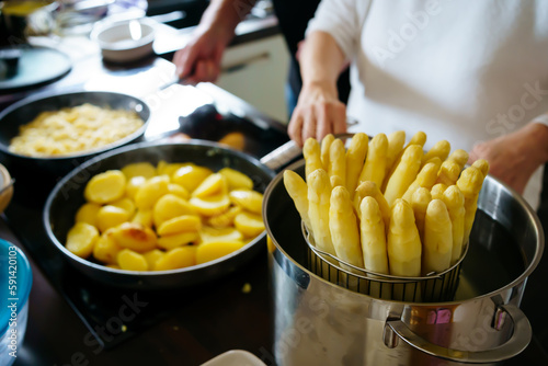 Old Woman cooking white asparagus in the kitchen
