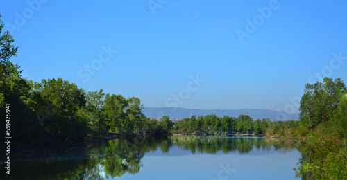 A beautiful summer morning river landscape with the river  trees and blue sky in the background. A town on the bank of a river. The nature of Eastern Siberia.