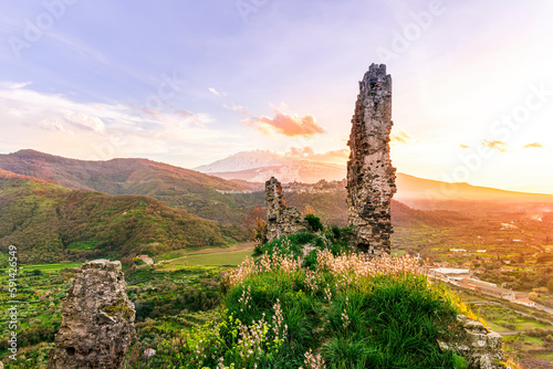picturesque view from a mountain with ancient monument or castle ruins to a green valley with amazing mountains on background of landscape and beautiful cloudy sky © Yaroslav