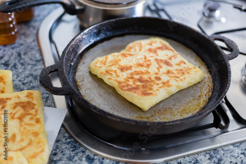 Cooking traditional moroccan rghayf or msemmen on a pan. Moroccan breakfast concept.