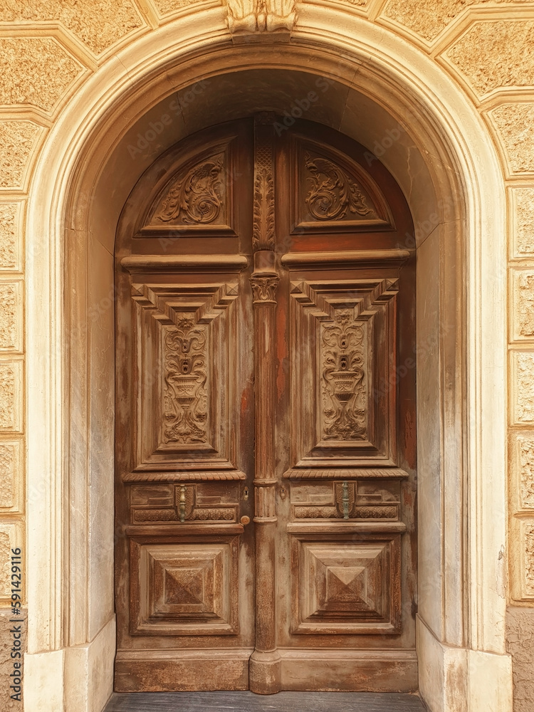 Ancient old door of a house on the street of Europe. Vertical.