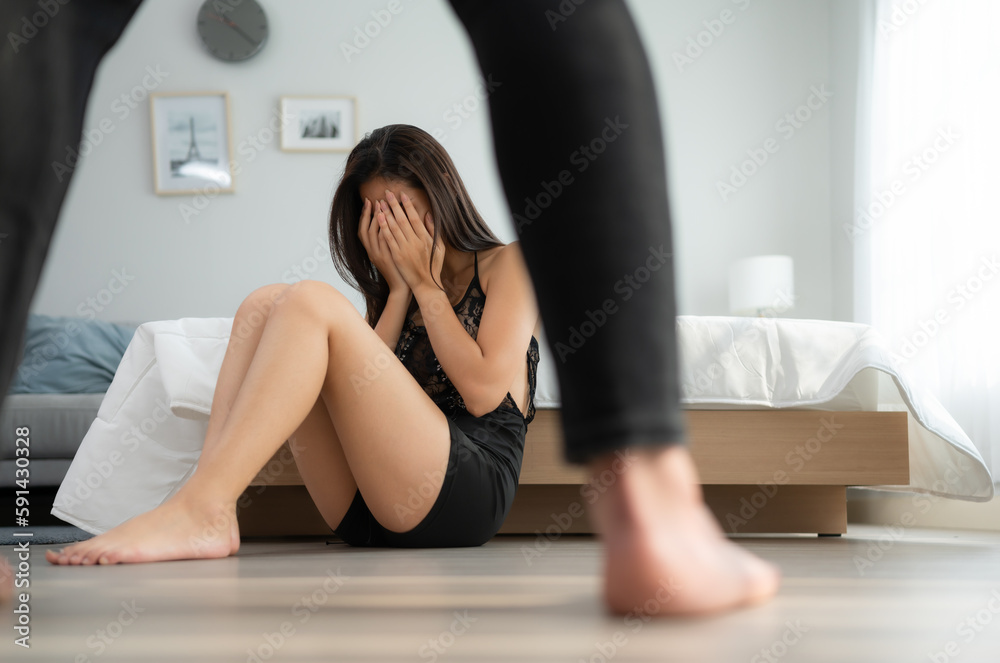 The enraged man scolding the frightened woman in the background. The concept of family and physical abuse The enraged man scolding the frightened woman in the background. The concept of family and physical abuse