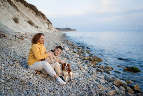 family walk on the seashore in the cold season. happy mother and son hugging each other