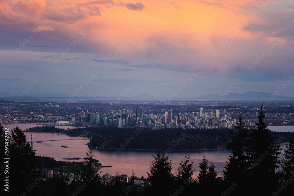 Aerial view of colorful sunset cloudscape over the river and Vancouver cityscape at a distance
