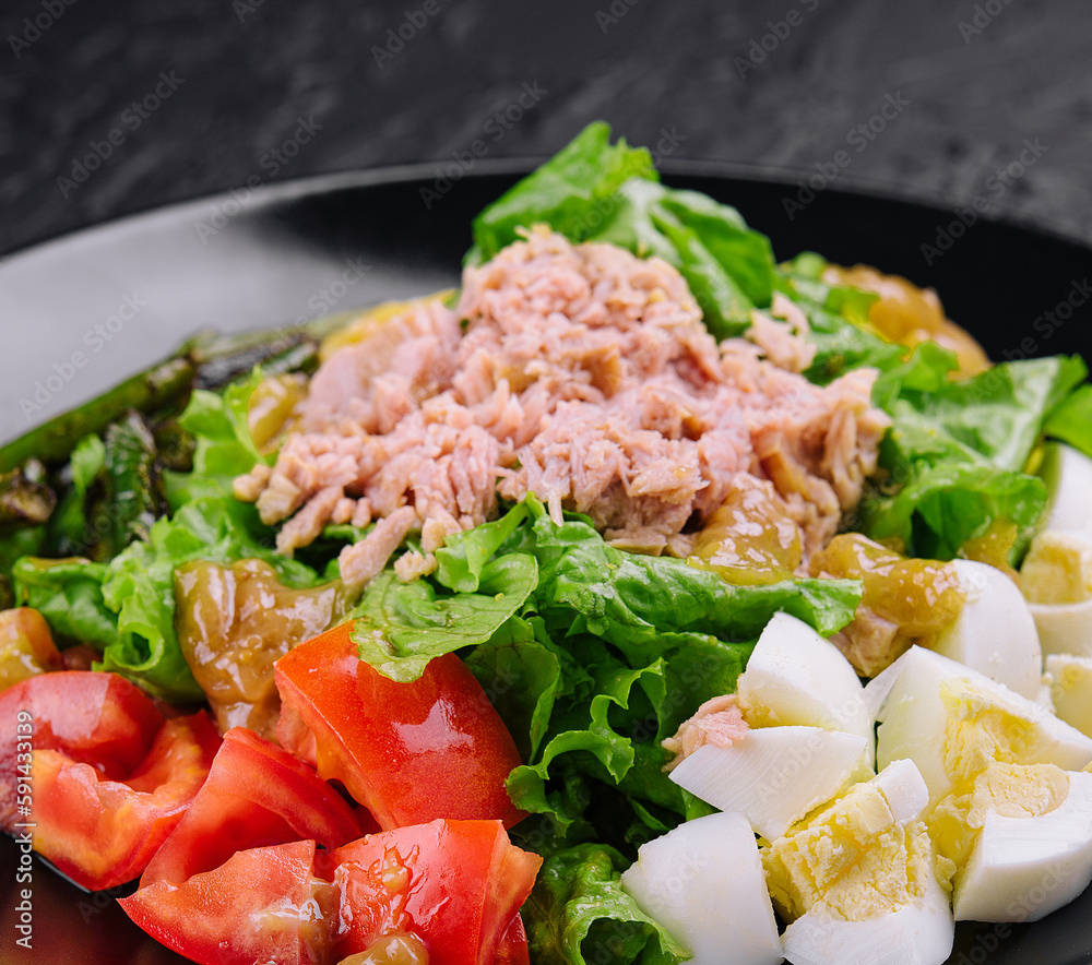 Tuna and vegetable salad on black plate Tuna and vegetable salad on black plate