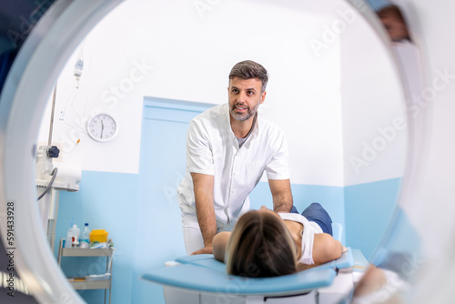 Professional Doctor Radiologist In Medical Laboratory Controls magnetic resonance imaging or computed tomography or PET Scan with Female Patient Undergoing Procedure.