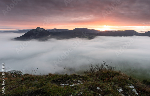 Panorama of autumn mountain over clouds with sun