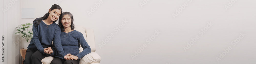 Mother's day concept, young adult female daughter congratulate excited asian elderly mother at sofa with birthday anniversary, two generations family photo, real people.