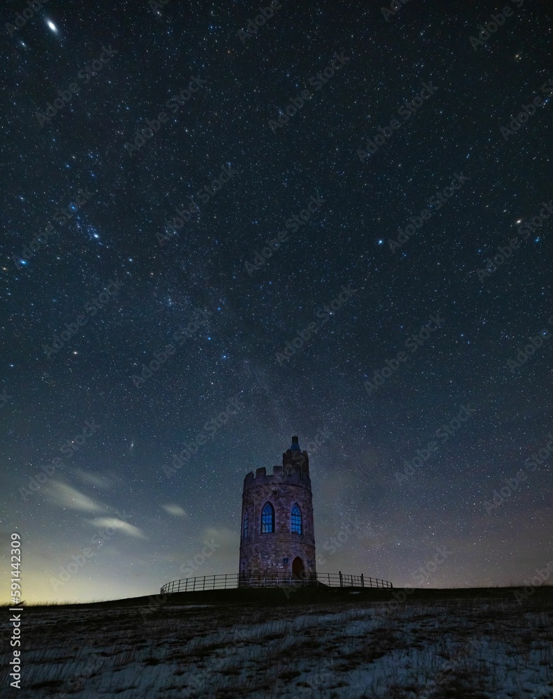 Vertical shot of the Hurlestone tower under the starry sky in Northumberland, UK Vertical shot of the Hurlestone tower under the starry sky in Northumberland, UK