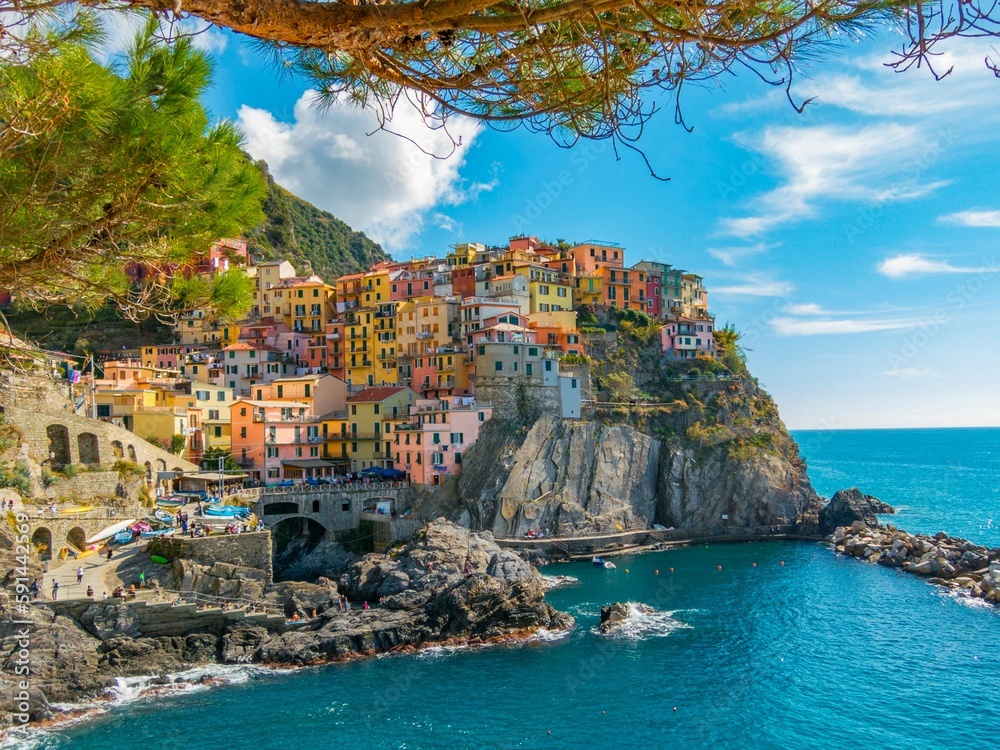 Cinque Terre seaside village on a sunny day, cloudy sky background