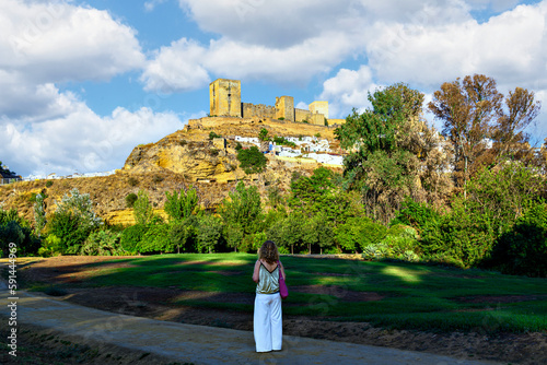 Blond curly haired woman looking at the castle of alcala de guadaira in seville photo