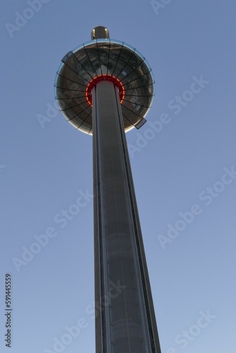 the tower is illuminated red against the blue sky behind it