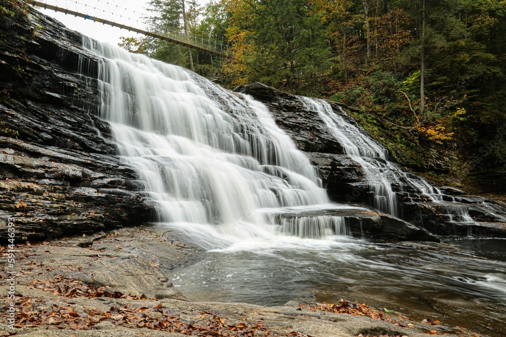 Obraz premium Landscape of a beautiful waterfall surrounded by rocks in a forest