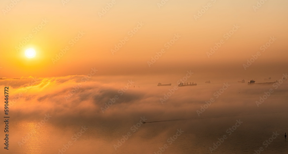 Majestic view of the fog covering the sea with the golden sunset in background