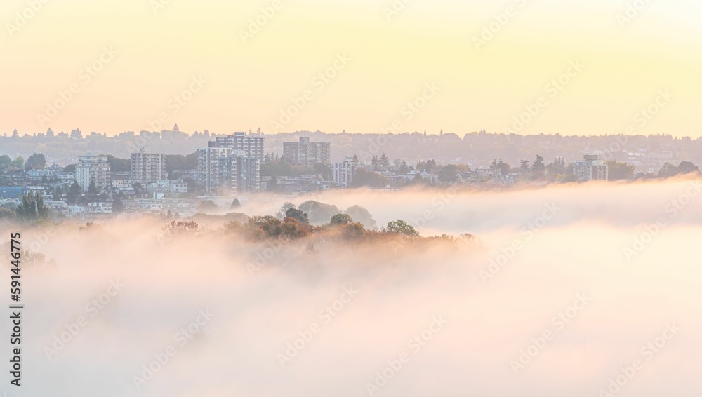 Stunning aerial view of a town peaking through dense fog
