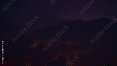 A large rain cloud with thunderstorms with lightning.