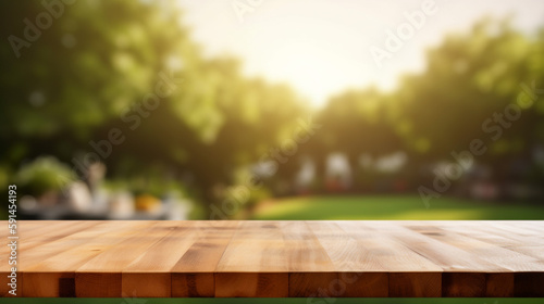 Fotografiet Empty wooden table in summer background with the blurred green garden and picnic or BBQ in the background