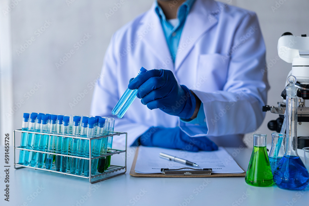 Medical or scientific researcher or male doctor looking at test tube of transparent solution in laboratory analysis Test tube with blue liquid in the laboratory Medical or scientific researcher or male doctor looking at test tube of transparent solution in laboratory analysis Test tube with blue liquid in the laboratory